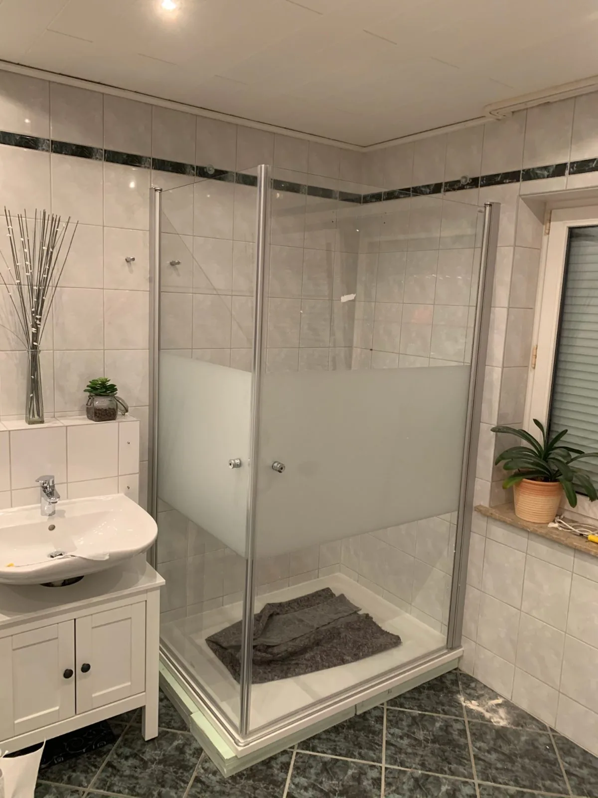 Dusche mit Glasabtrennung, Fliesenband auf Augenhöhe