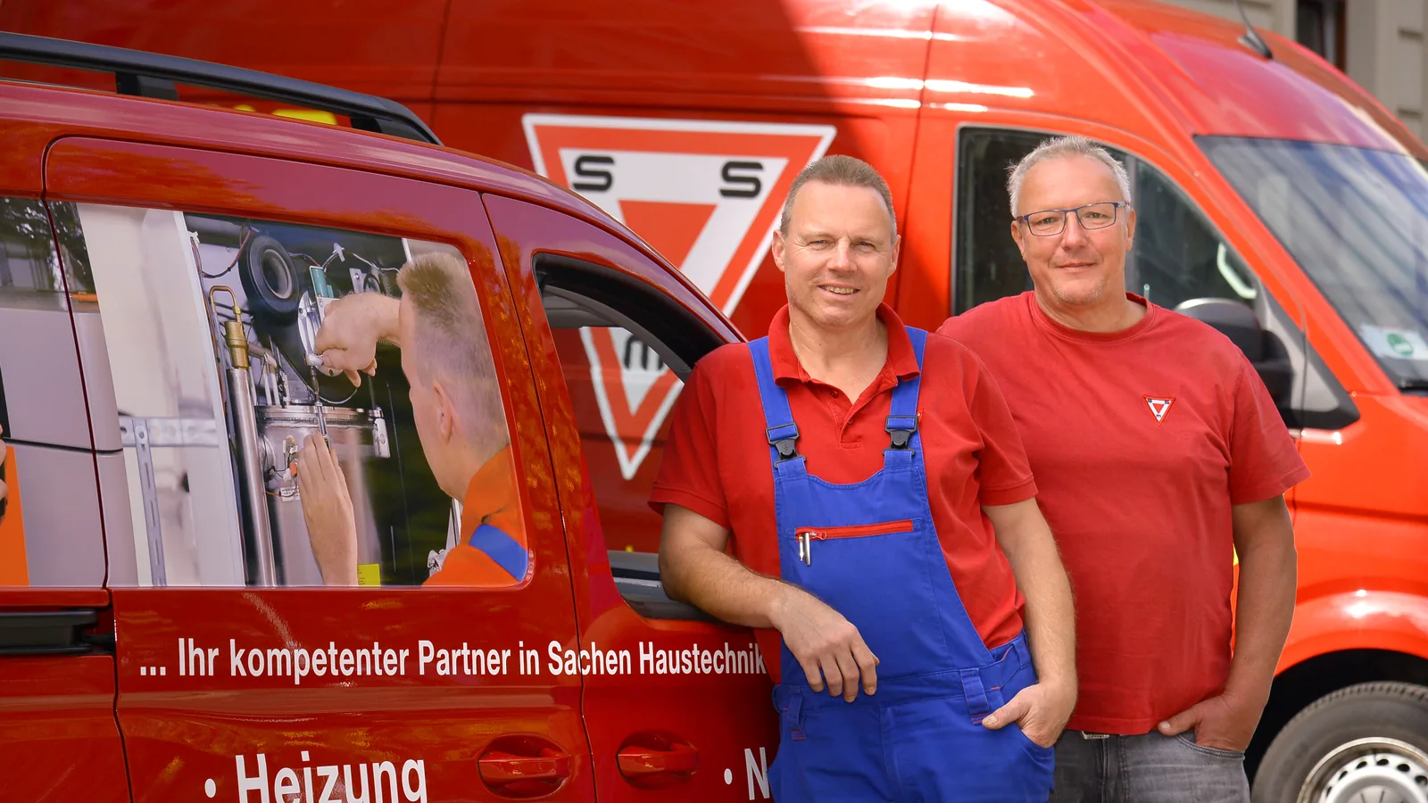 Zwei Kundendienst-Monteure vor dem Servicewagen
